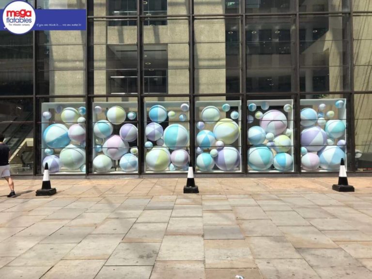 Multiple Inflatable Beach Balls Behind Six Glass Walls